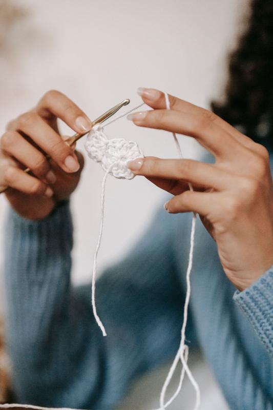 Hands crocheting white cotton yarn
